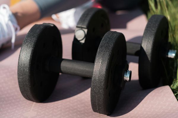 Close-up of fitness equipment like resistance bands and weights on a mat.